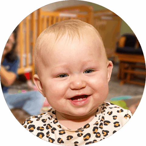 A smiling baby with blonde hair in Celebree School of Bel Air infant classroom.  