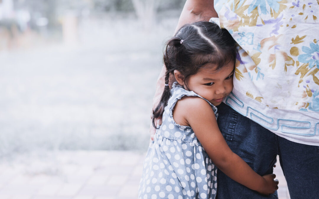Sad asian little girl hugging her mother leg in vintage color tone