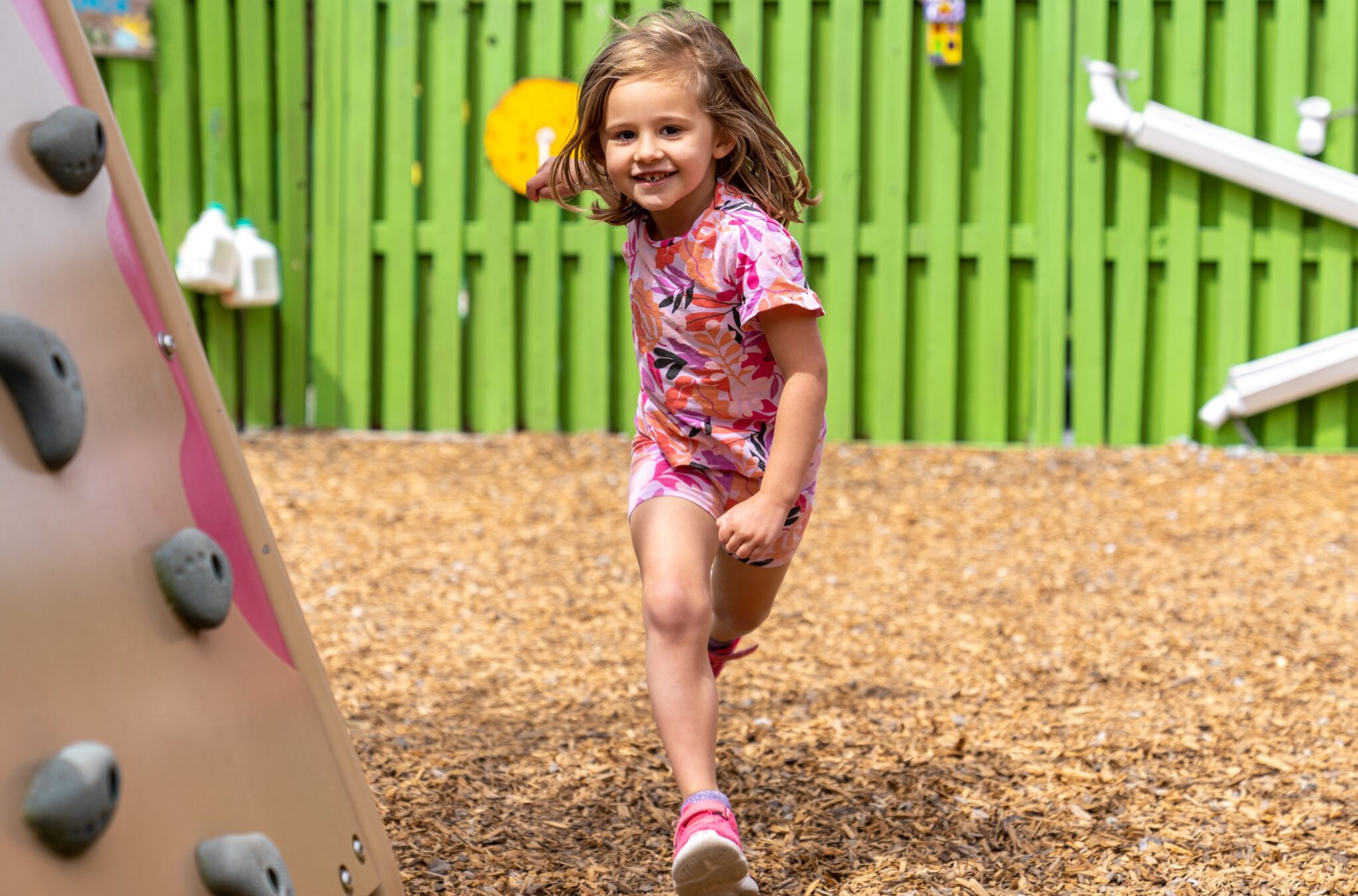 Preschool age girl running on a playground.