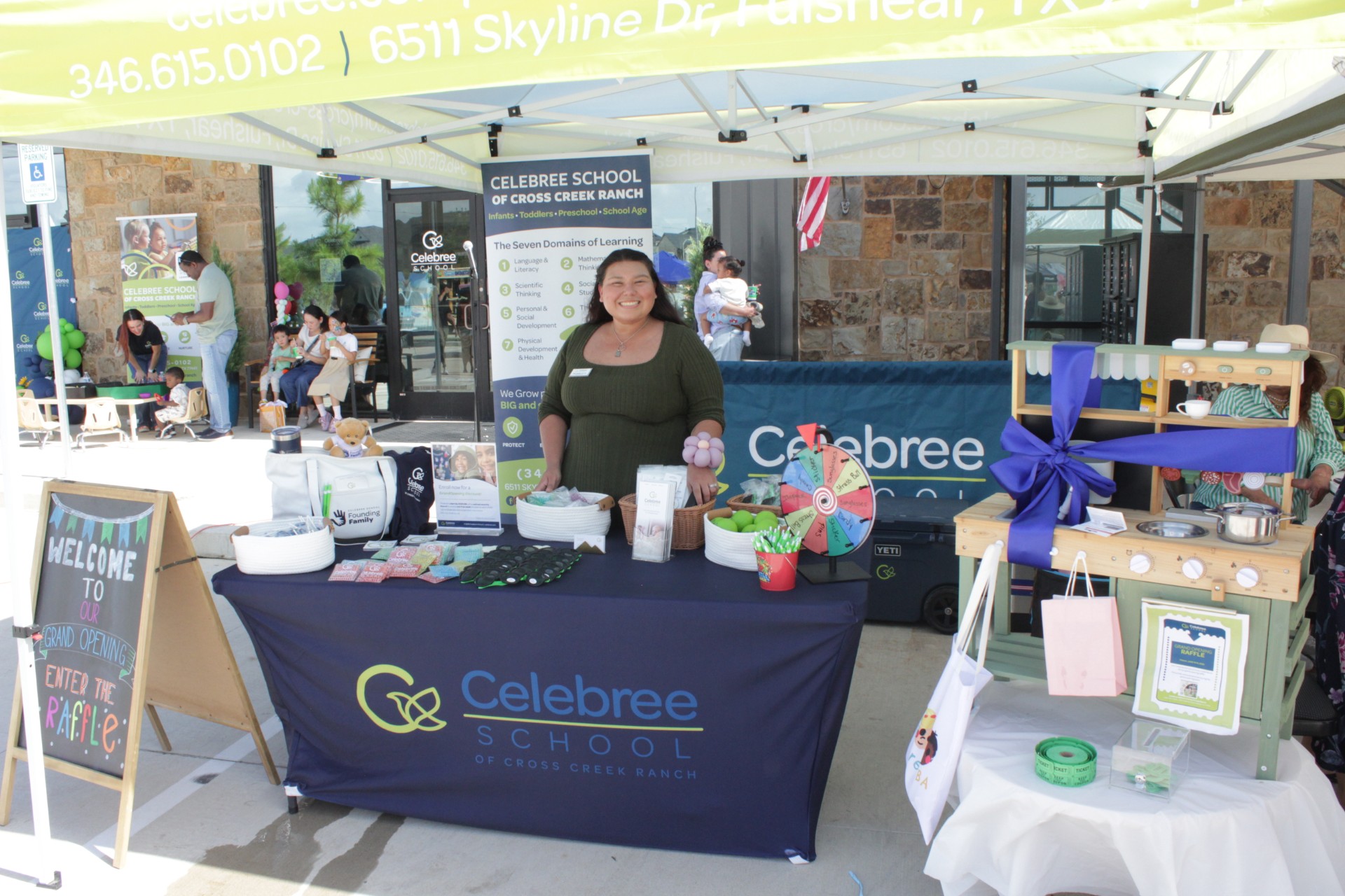 Welcome table at the Celebree School of Cross Creek Ranch grand opening featuring giveaways, family activities, raffle prizes, and enrollment information for local families.
