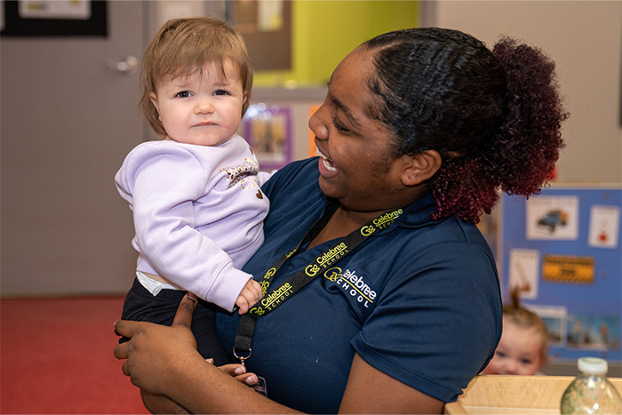 Celebree Daycare teacher cuddling an infant in a childcare classroom