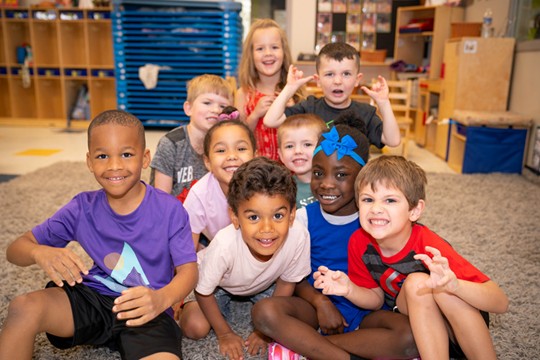 A group of kids at Celebree School gathered together and smiling or making funny<br />
faces