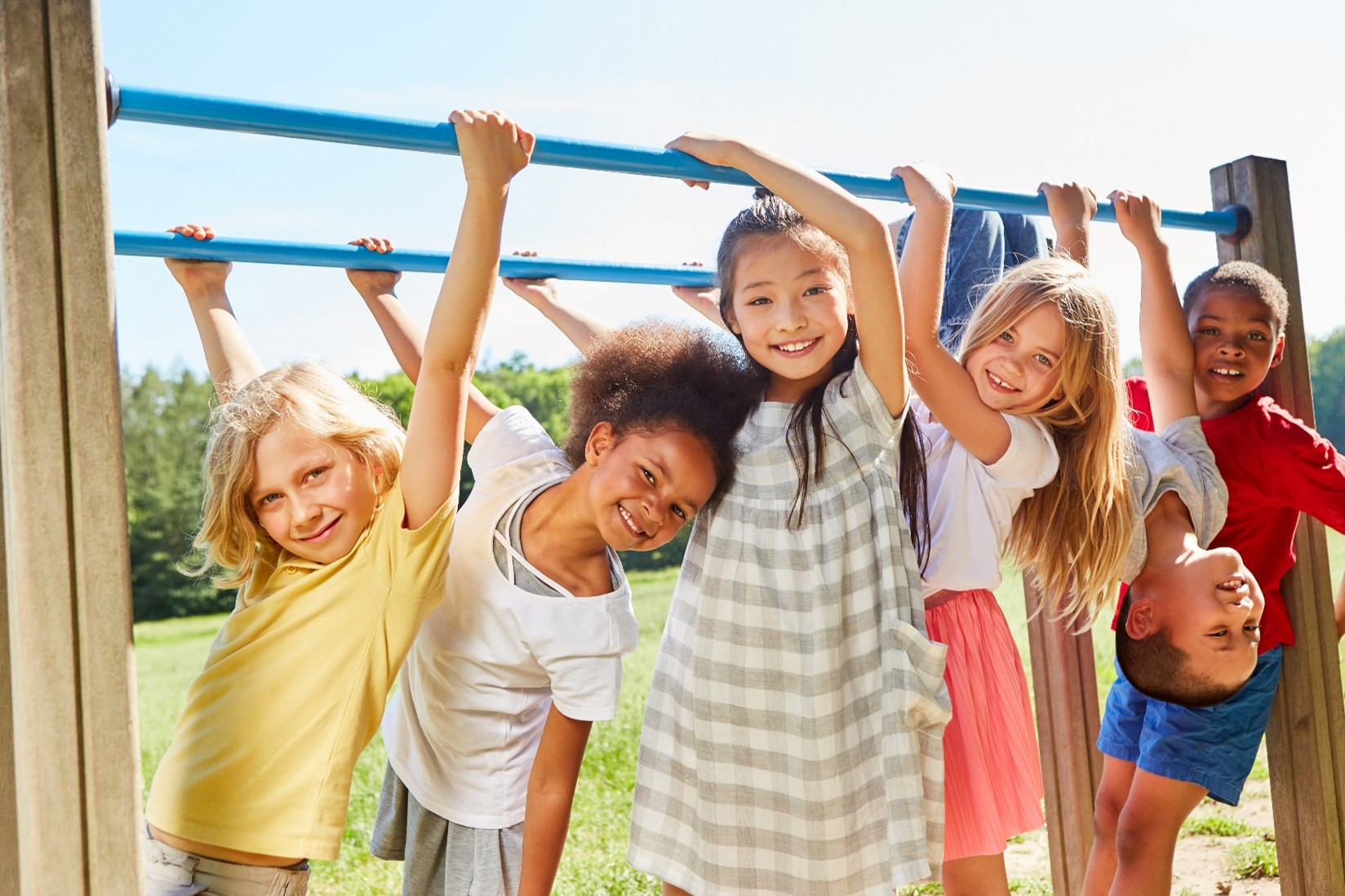 children hanging on the monkey bars