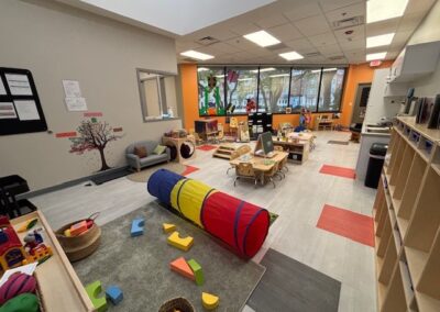 Bright and spacious preschool classroom with colorful play areas.