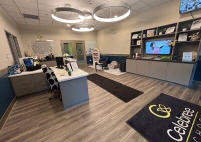 Reception area of Celebree School with a desk, seating, and TV.