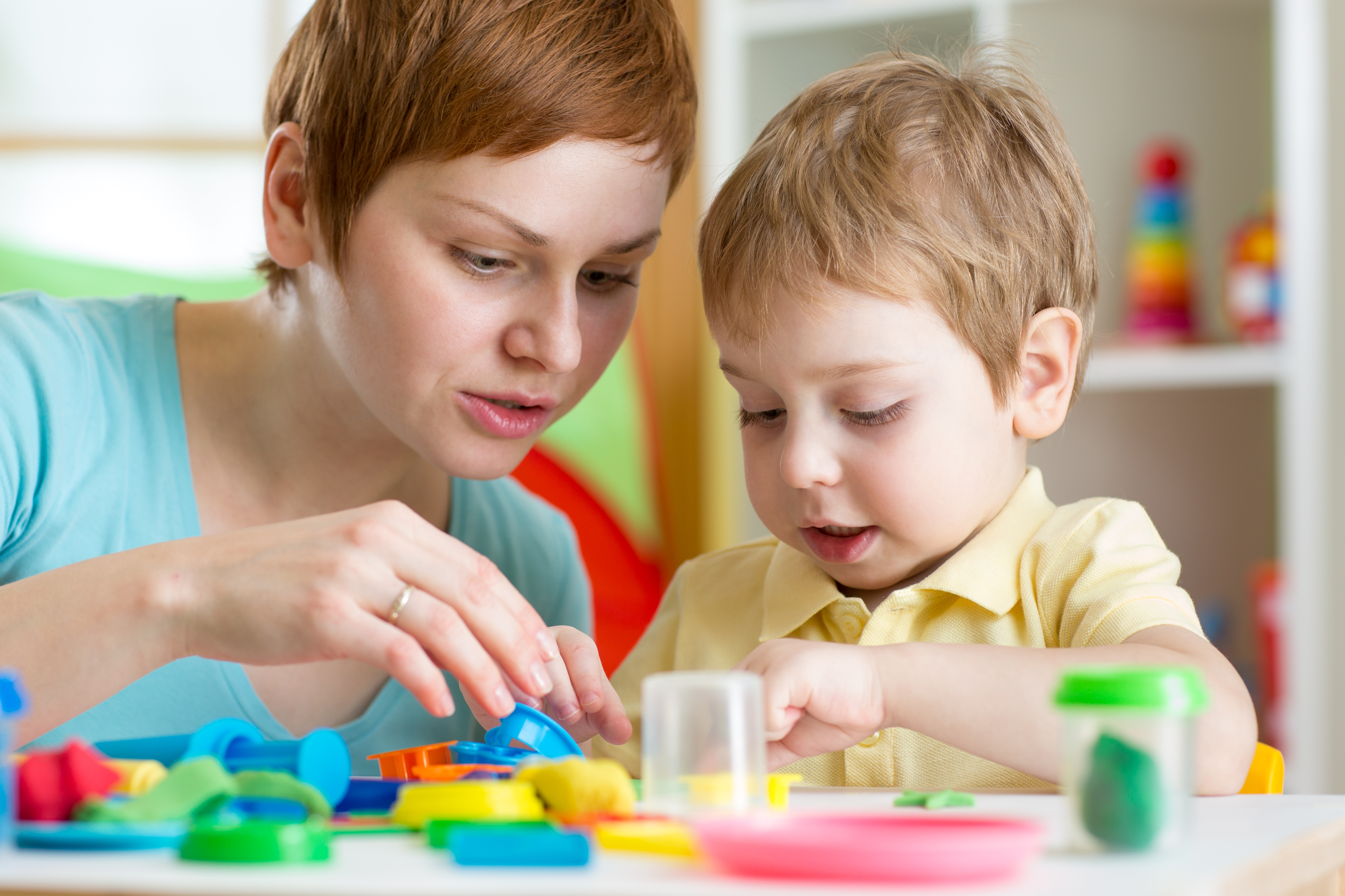 child boy and mother playing colorful clay toy