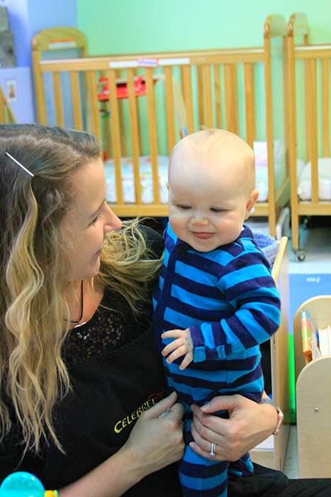 A teacher holding a baby