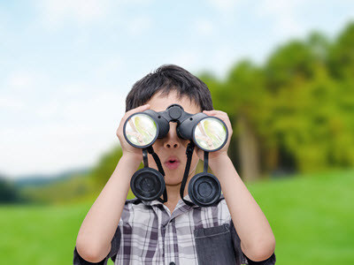 boy at summer camp in Bear, DE looking through binoculars
