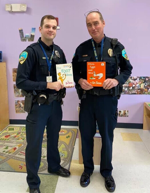 Police officers read to students at a Celebree School on community helper day
